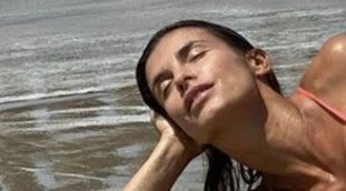 Elisabetta Canalis, "fuori di petto" in spiaggia: distesa in bikini sulla sabbia, due foto incendiarie