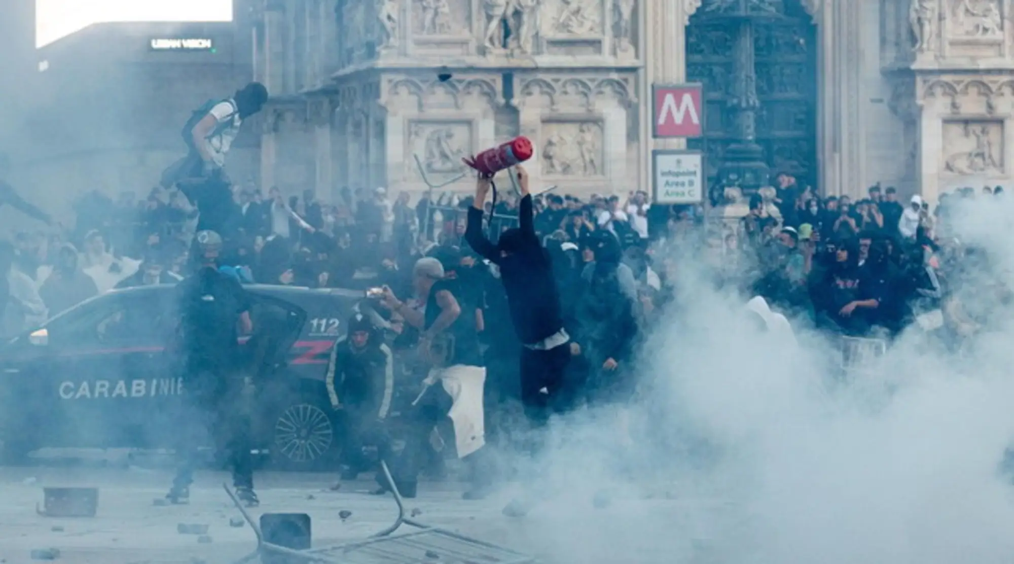 Milano, guerriglia in piazza Duomo: bombe carta e tavolini contro la polizia, che risponde con idranti e cariche