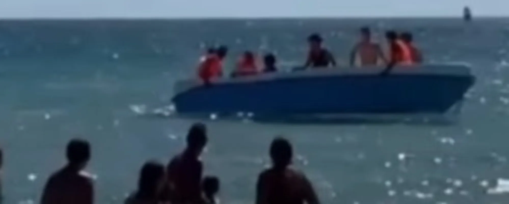 La folle corsa del barchino di clandestini (cacciati dai bagnanti): il video impressionante