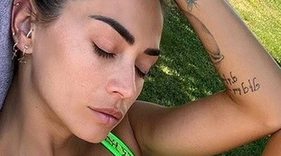 Melissa Satta, gomito sul ginocchio e primo piano da urlo: slip verde fluo, uno show piccantissimo