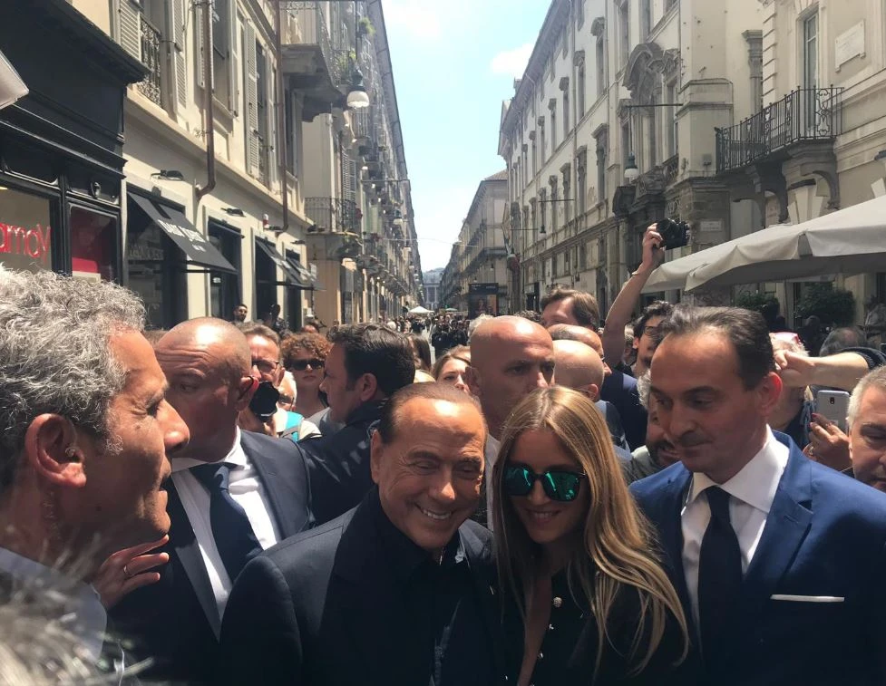 Silvio Berlusconi non si smentisce mai. Accolto dalla piazza a Torino "conquista" una giovane bionda