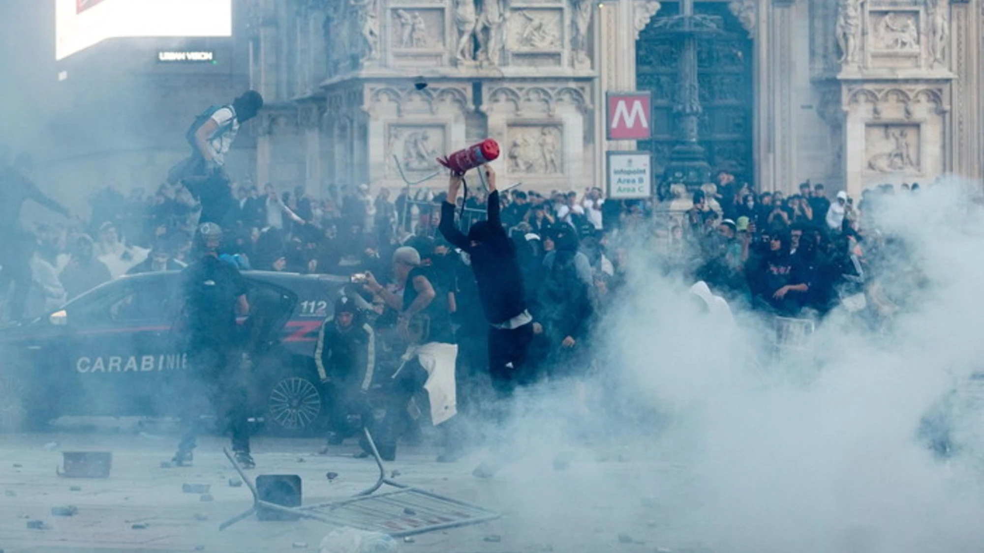 Milano, guerriglia in piazza Duomo: bombe carta e tavolini contro la polizia, che risponde con idranti e cariche