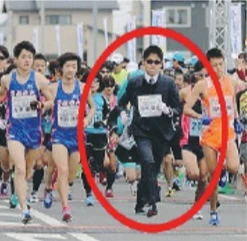Il maratoneta che corre in abito e scarpe lucide (e batte pure i record)