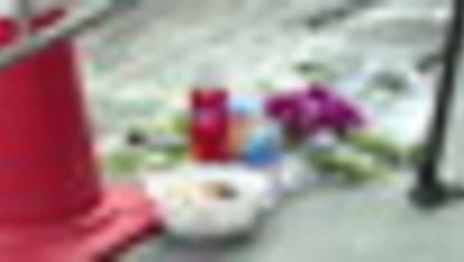 Fiori bianchi e colorati depositati davanti all'ingresso del bar danneggiato dalle fiamme a Bangkok