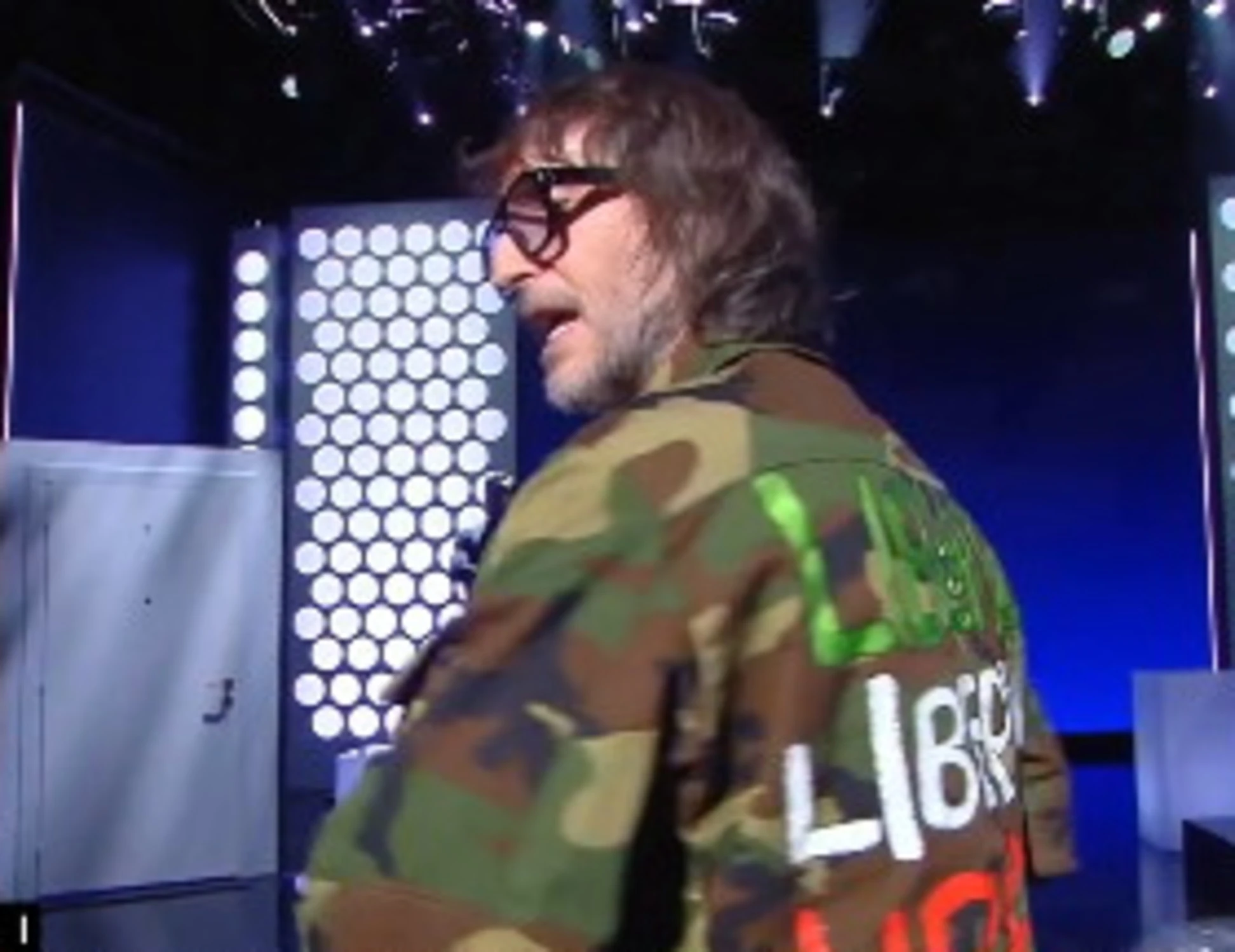 Fuori dal coro, Cruciani in giacca militare: la scritta sulla schiena, pugno a toghe e sinistra