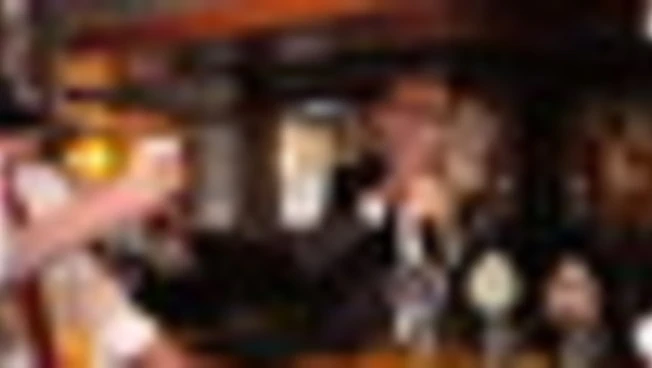 Andy Burnham festeggia il taglio delle tasse al pub con birra in mano