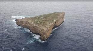 Sicilia, 35 migranti bloccati su uno scoglio: "Costretti a lanciargli cibo"