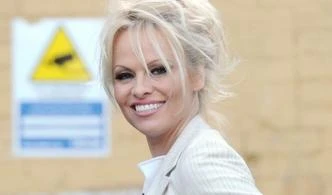 Pamela Anderson, abitino color panna e spacco da urlo